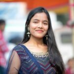 Portrait of a young woman in colorful traditional Indian clothing at an outdoor event.