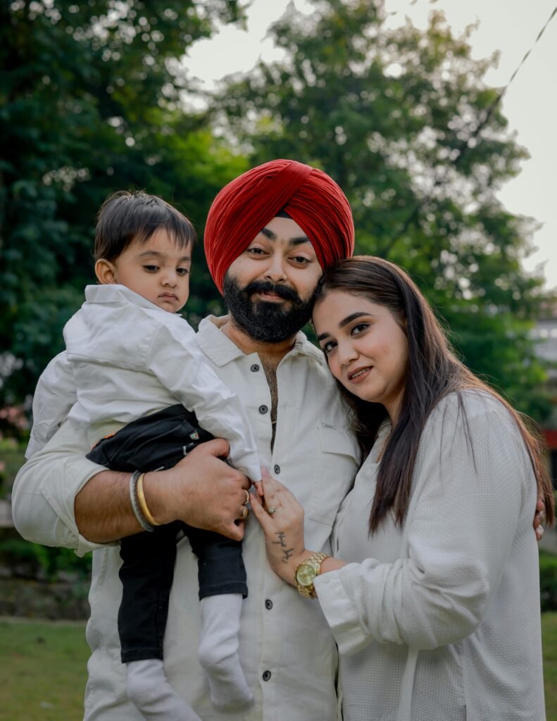 A joyful family portrait featuring parents and their child in a serene park environment.